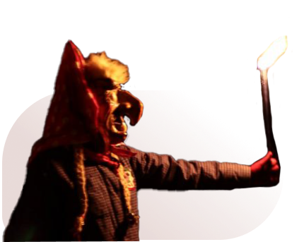 Person mit Hexenmaske und spitzem Hut hält eine brennende Fackel in ausgestreckter Hand.